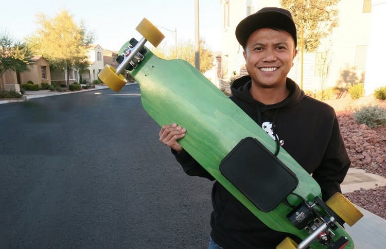 Holding Green Electric Skateboard