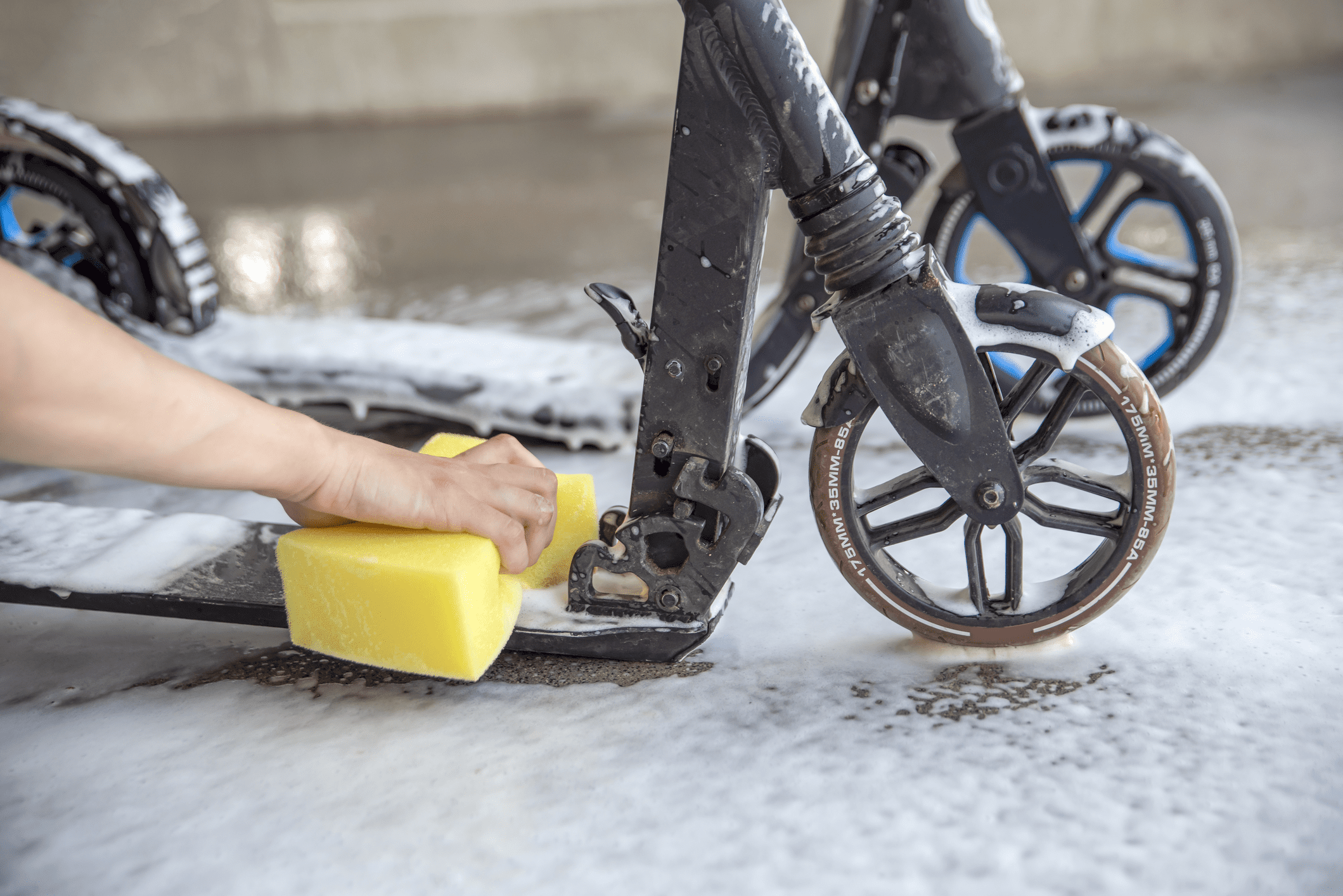cleaning electric scooter with a sponge