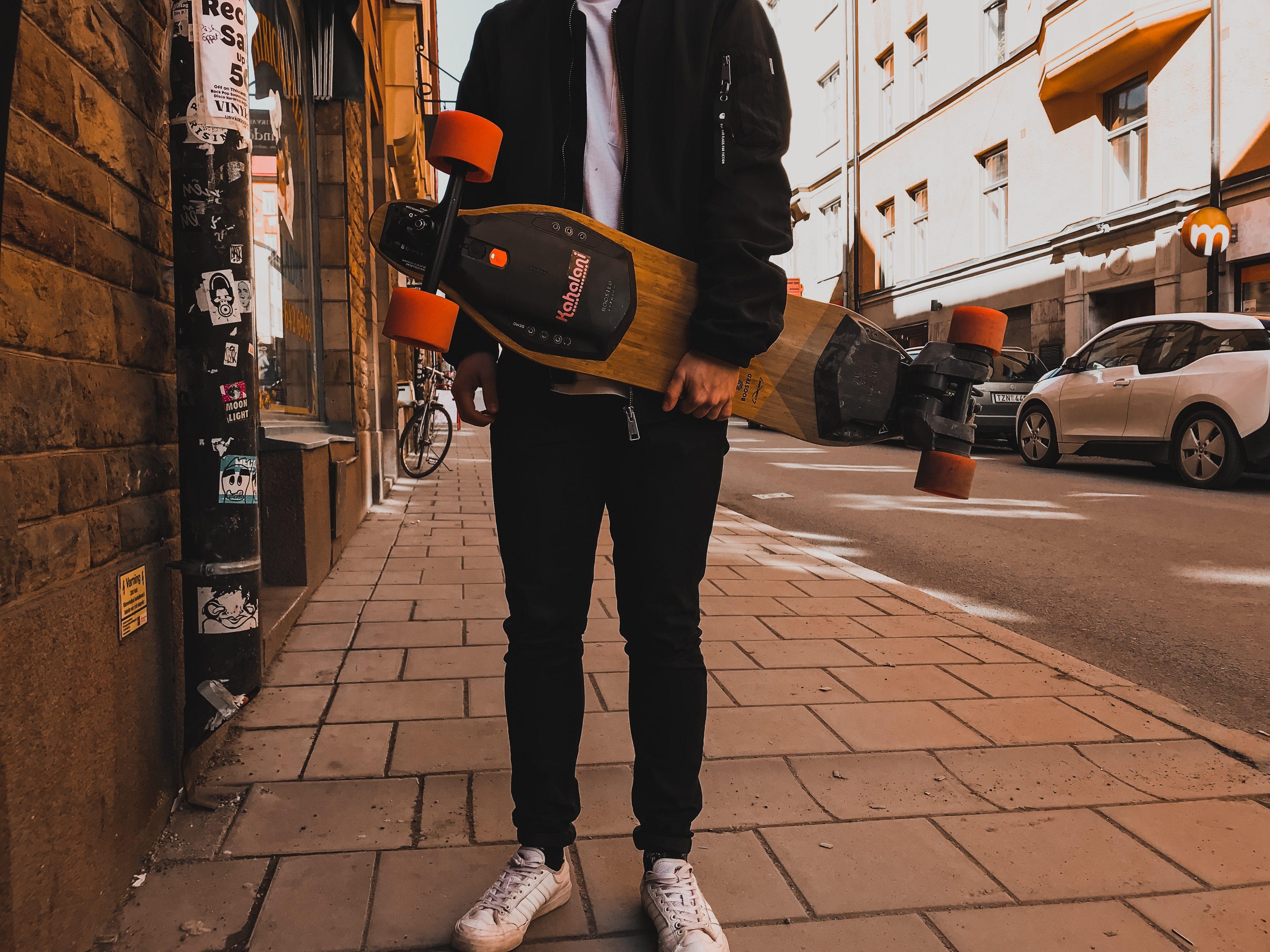 Guy holding electric skateboard